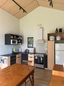 Modern kitchen renovation by home renovators in Auckland featuring custom cabinetry, stone benchtops, and sleek lighting design.