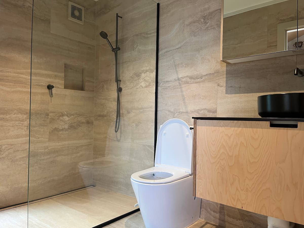 Modern tiled bathroom renovation with walk-in shower, vanity and high-end fixtures in Auckland
