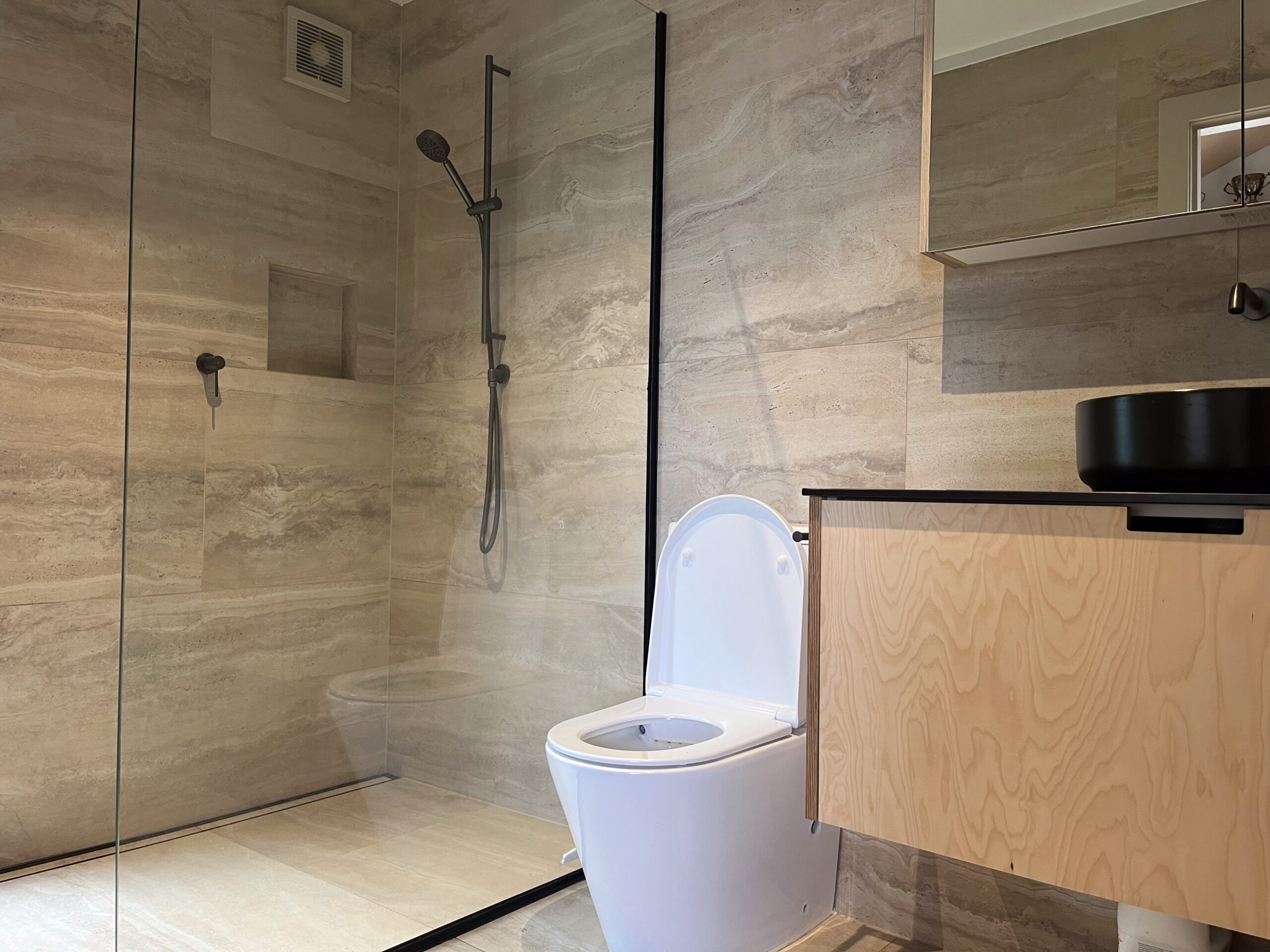 Modern tiled bathroom renovation with walk-in shower, vanity and high-end fixtures in Auckland