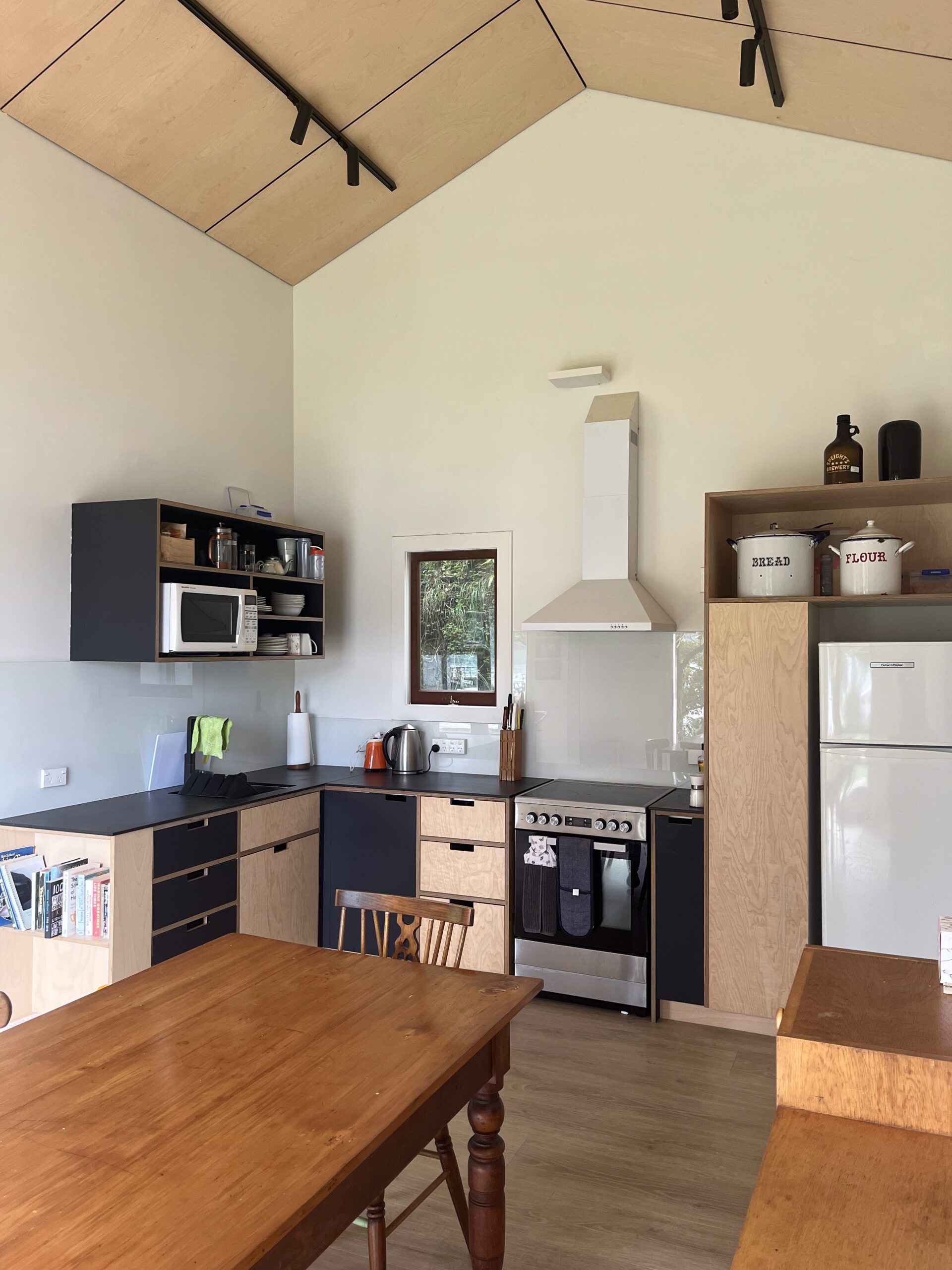 Modern kitchen renovation by home renovators in Auckland featuring custom cabinetry, stone benchtops, and sleek lighting design.